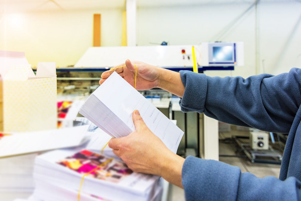 Person printing marketing material (How Print Can Differentiate your Business From The Competition)
